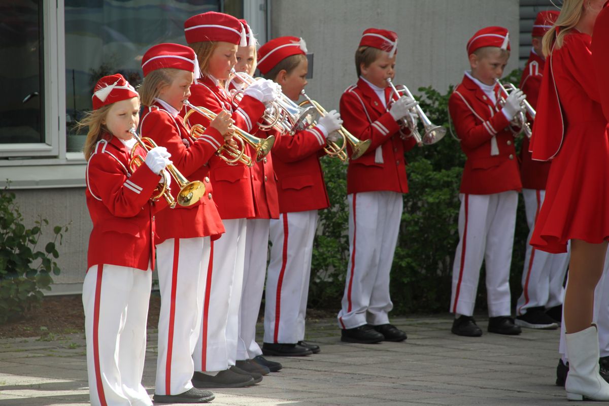 Musikanter i rød uniform spiller sammen